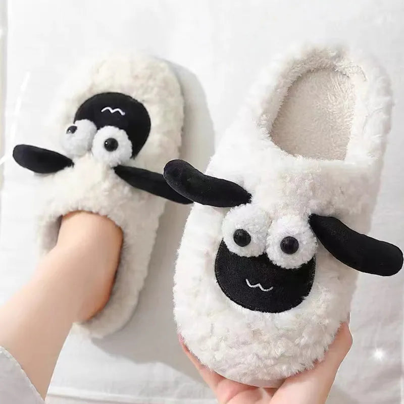 Brown suede slip-on slippers with a light-coloured PVC sole on a wooden floor.