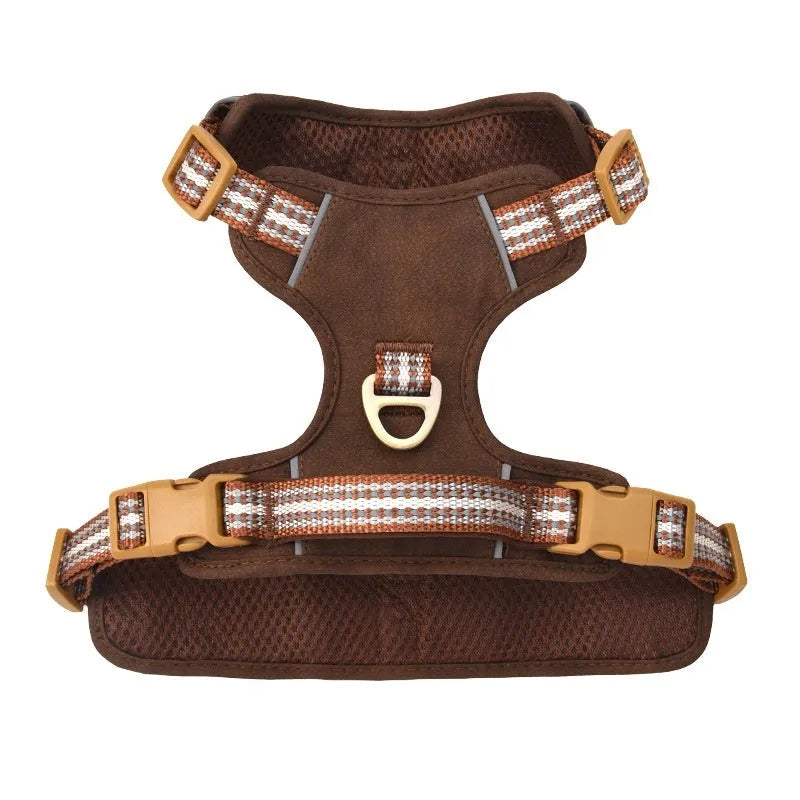Brown leather dog harness with reflective strips and chest clip.