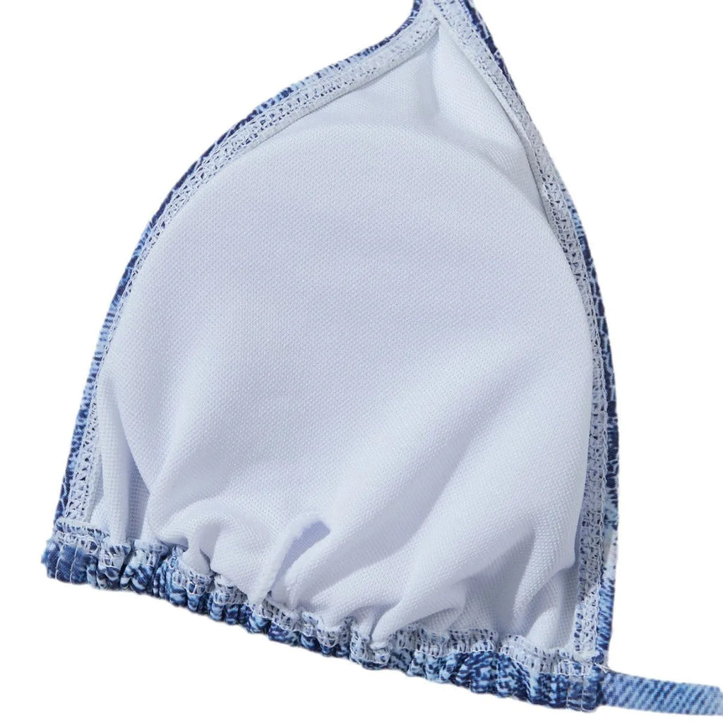 Denim blue women's bikini set with printed design and strap details laid flat.