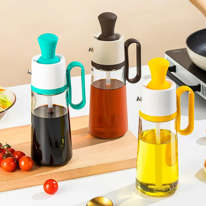 550ml clear glass oil dispenser bottle with stainless steel spray nozzle and a yellow silicone brush head attached.