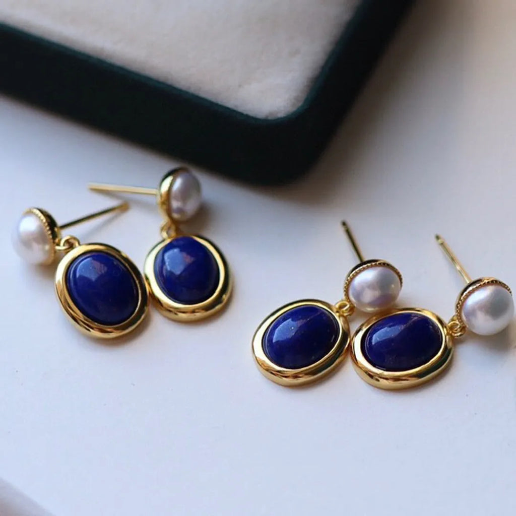 A pair of silver earrings with blue lapis lazuli pearls and auspicious patterns.