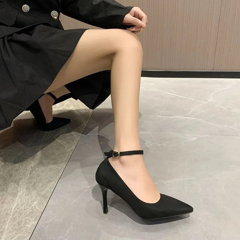 Black women's stiletto heel pumps with a skull pattern and buckle detail on a white background.