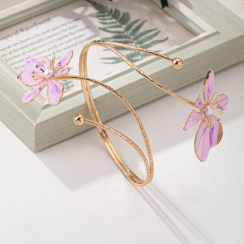 Pink adjustable alloy armband with hollow line pattern on a wrist, showing open-ended design.