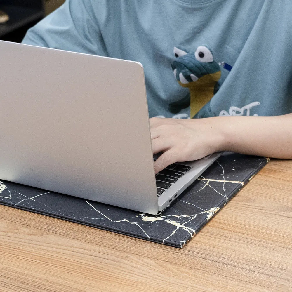 Durable black laptop cooling pad with printing pattern and anti-radiation features on a desk.