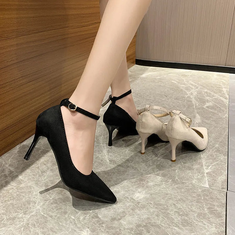 Black women's stiletto heel pumps with a skull pattern and buckle detail on a white background.
