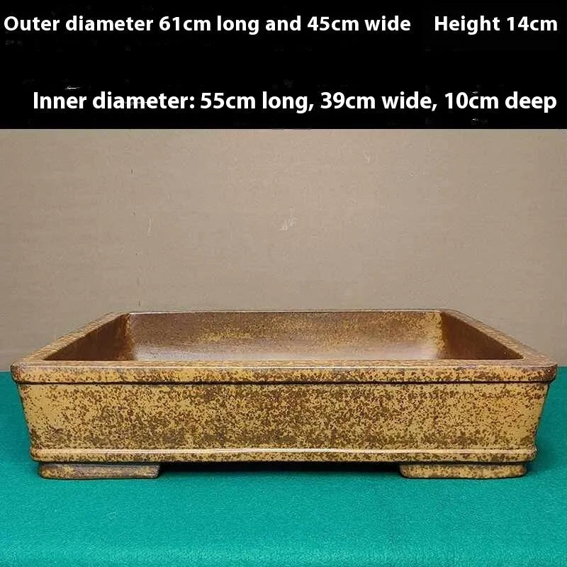 Straight-sided shallow rectangular flowerpot made from natural, unglazed purple sand clay, shown empty on a wooden surface.