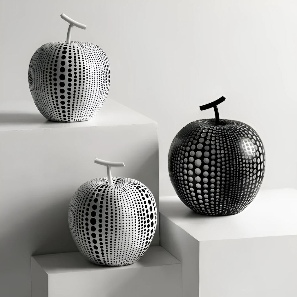 Handmade resin apple and pear decorative sculptures in various colours on a shelf