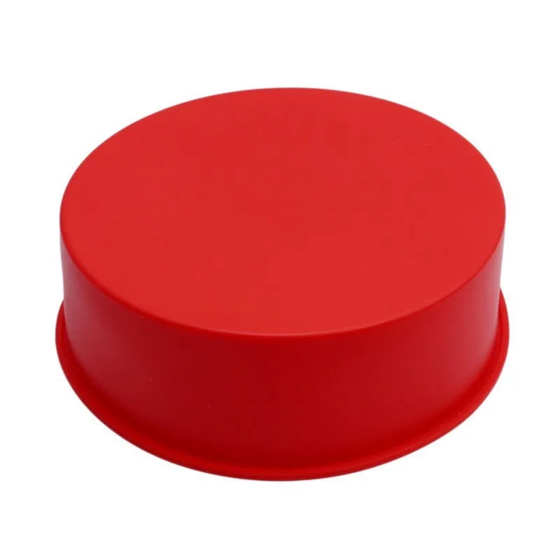 Set of three bright red round silicone cake moulds in 4-inch, 6-inch, and 8-inch sizes on a kitchen counter.