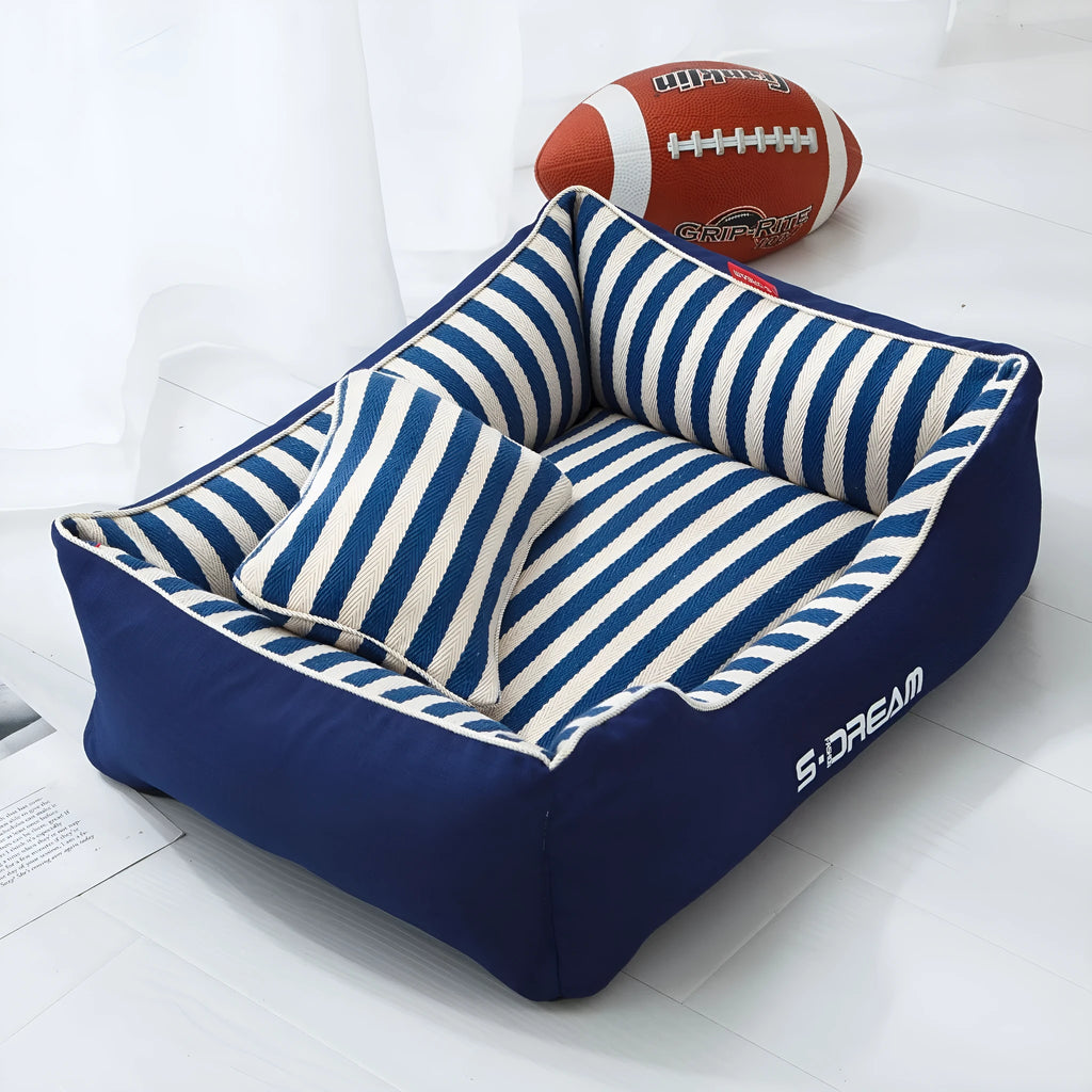 Navy stripes washable dog kennel mat with a blue mini pillow inside a crate.