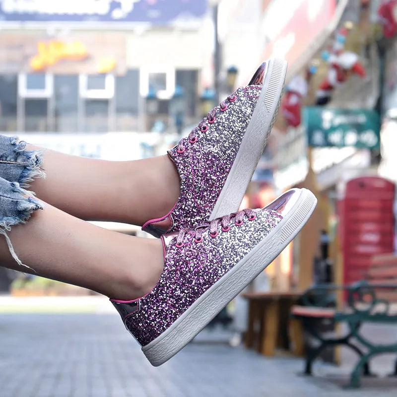 Women's black, gold, and pink sequinned low-top lace-up shoes on a white background.