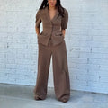 Brown men's slim fit polyester suit with long sleeve top and trousers laid flat.