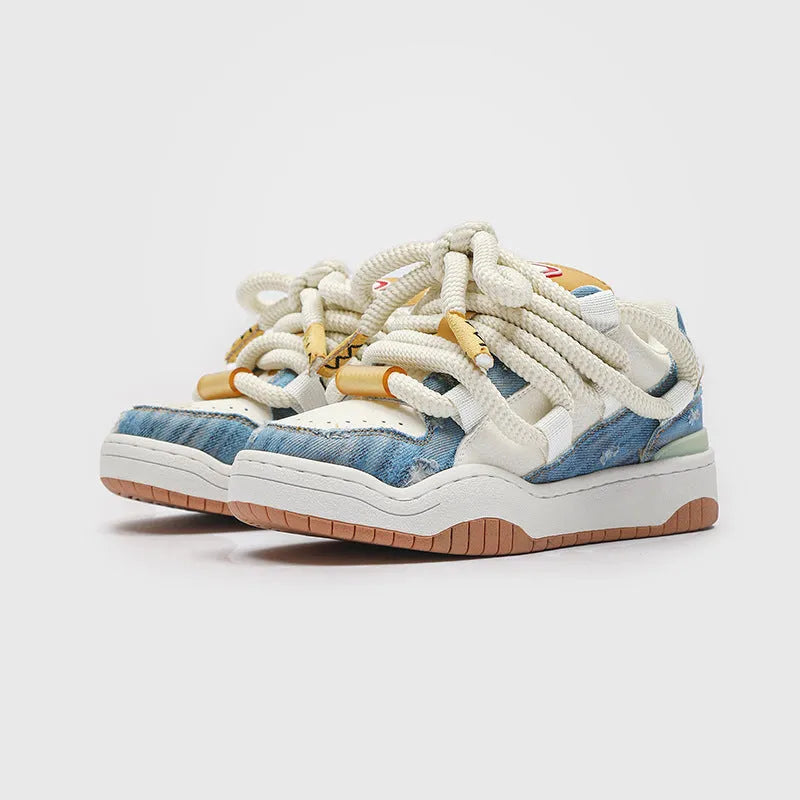 Pair of low-top unisex casual sneakers with thick flat rubber sole and lace-up front in a solid colour.