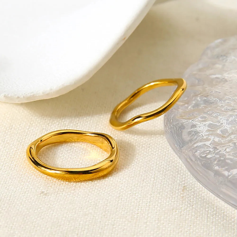 Irregular wave stainless steel ring in colour NXR28 on a plain background, unisex size No 6