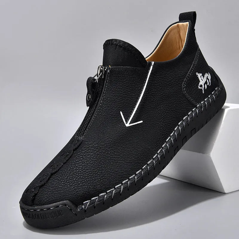 Men's black leather ankle boots with a front zip and round toe on a rubber sole