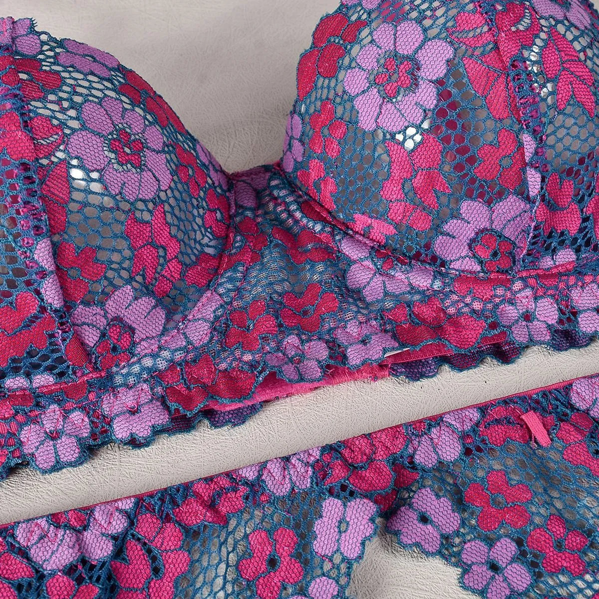 Rose red women's two-piece bikini with embroidered contrast detail on a mannequin.