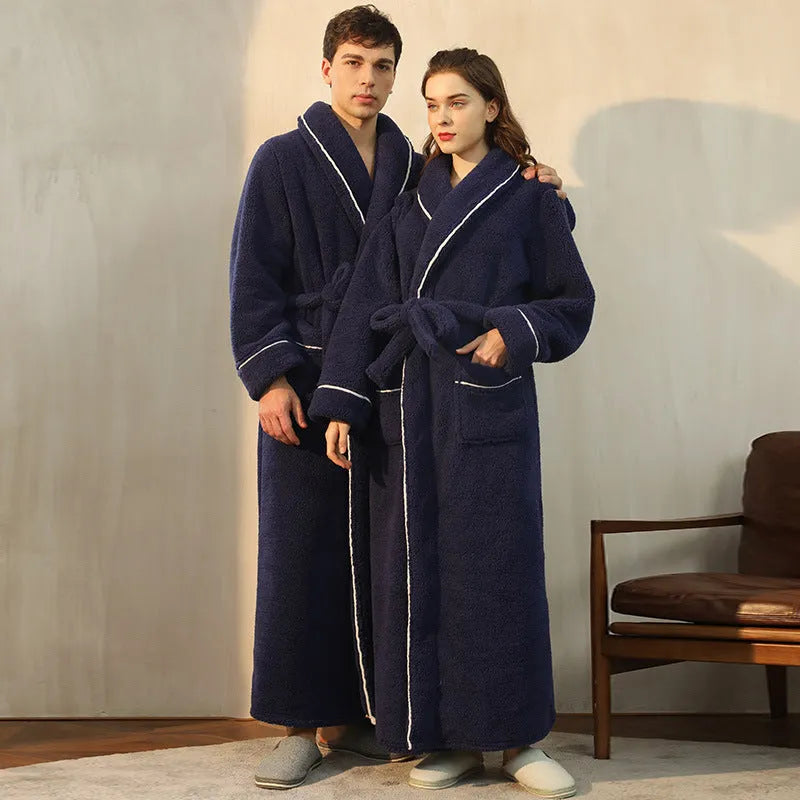 Man and woman wearing matching thick navy blue flannel bathrobes, showcasing the extended length and winter fabric.