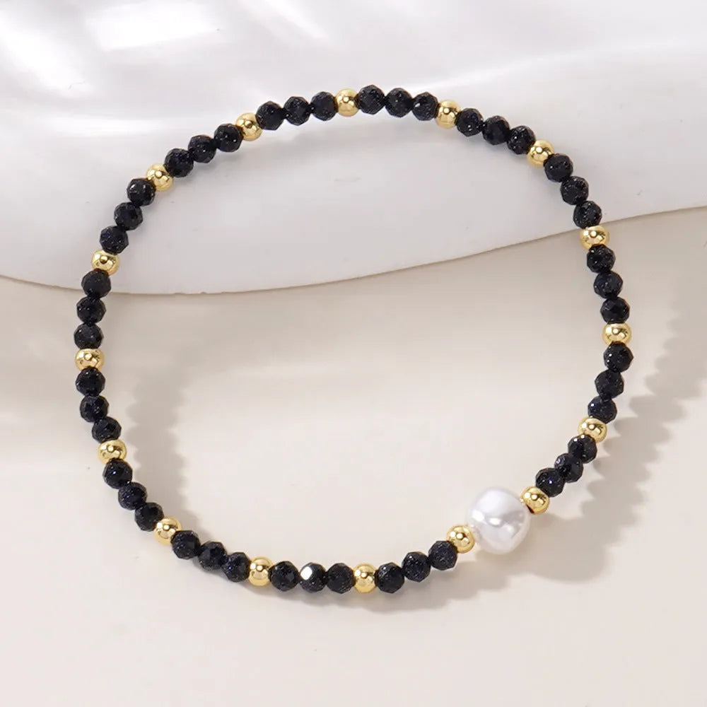 A unisex natural stone bracelet with elliptical geometric beads on a wrist, shown in one of the multiple available colours.