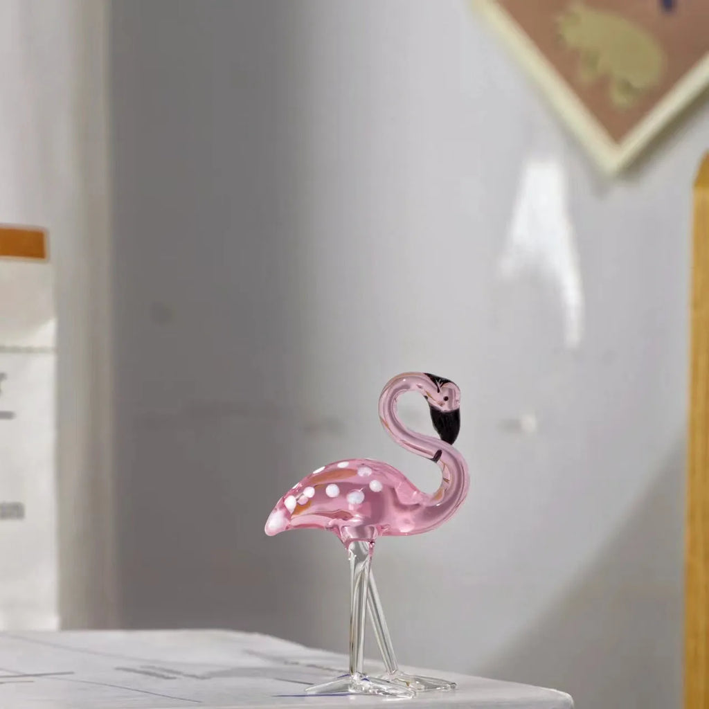 Pink flamingo decorative ornament made of white crystal on a table.