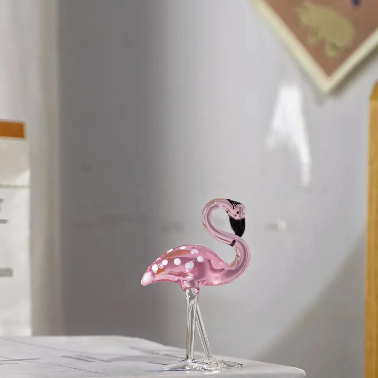 Pink flamingo decorative ornament made of white crystal on a table.