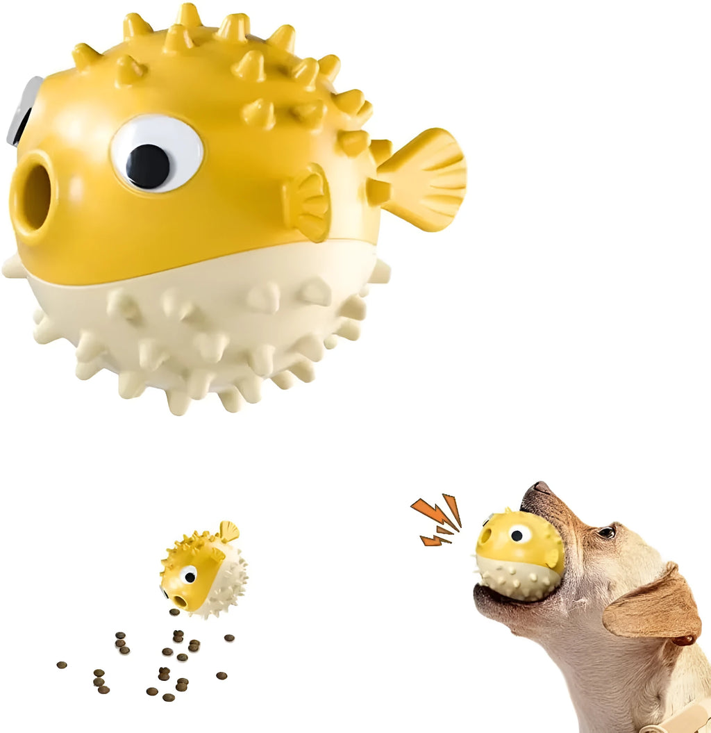 Green fish-shaped interactive dog toy with treat hole and textured surface, shown next to dog treats.