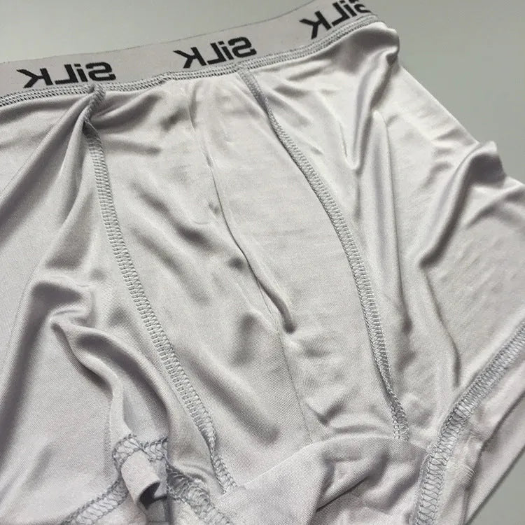 Men's loose fit silk shorts in navy blue on a mannequin, showing mid-waist design.