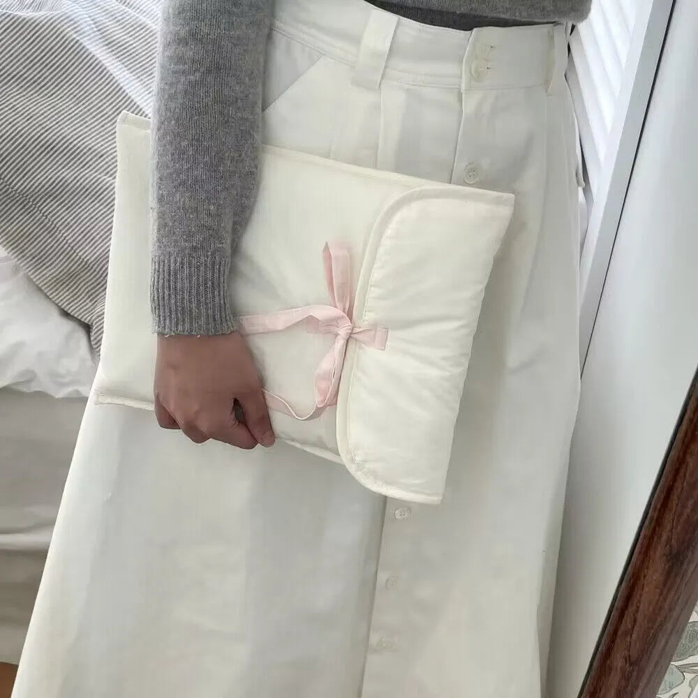 Black and white women's quilted nylon laptop bag with a ballet-style bow.