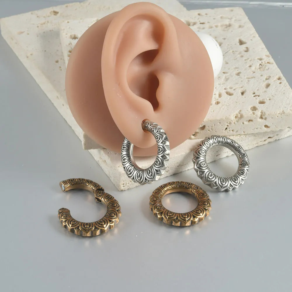A pair of large, geometric dragon-shaped alloy earrings with an antique silver finish and hollow-out details.