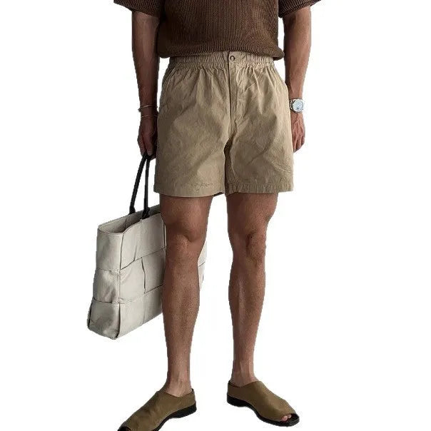 Man's loose-fit cotton sports shorts in black, showing elastic waistband with drawstring.