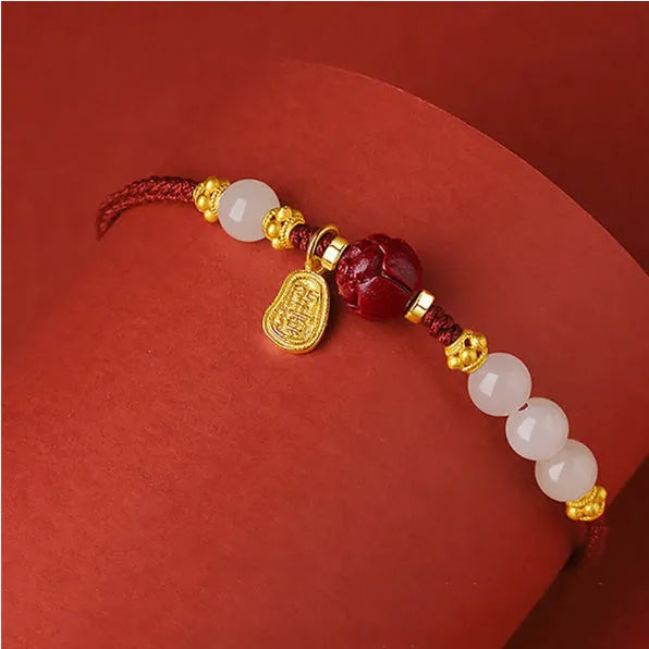 Adjustable silver bracelet with red Hetian jade detail on a wrist.