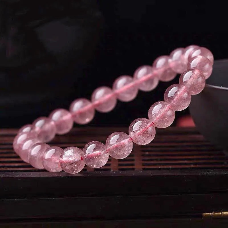 Women's strawberry quartz crystal bracelet with polished beads in 6mm, 8mm, and 10mm sizes
