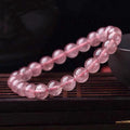 Women's strawberry quartz crystal bracelet with polished beads in 6mm, 8mm, and 10mm sizes