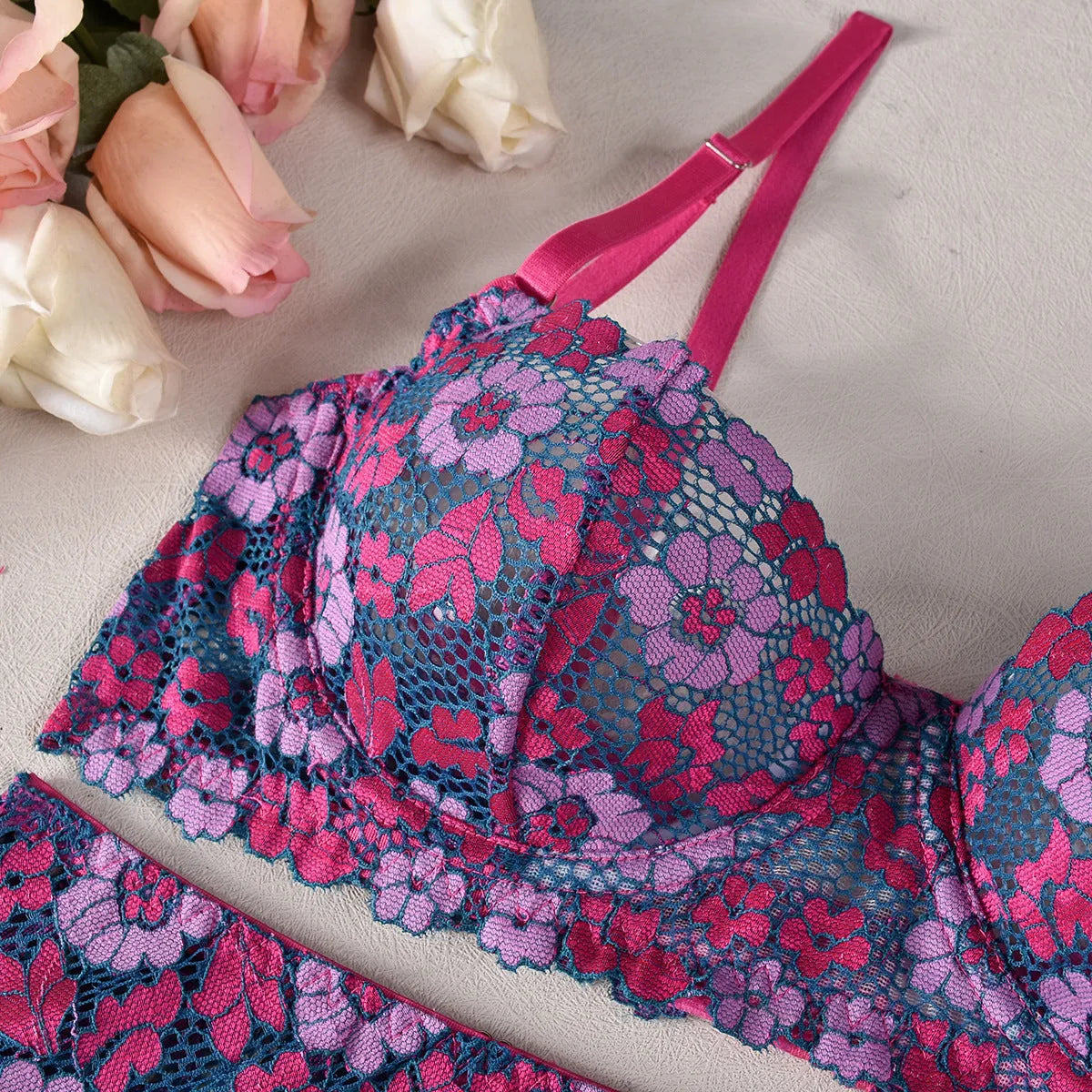 Rose red women's two-piece bikini with embroidered contrast detail on a mannequin.