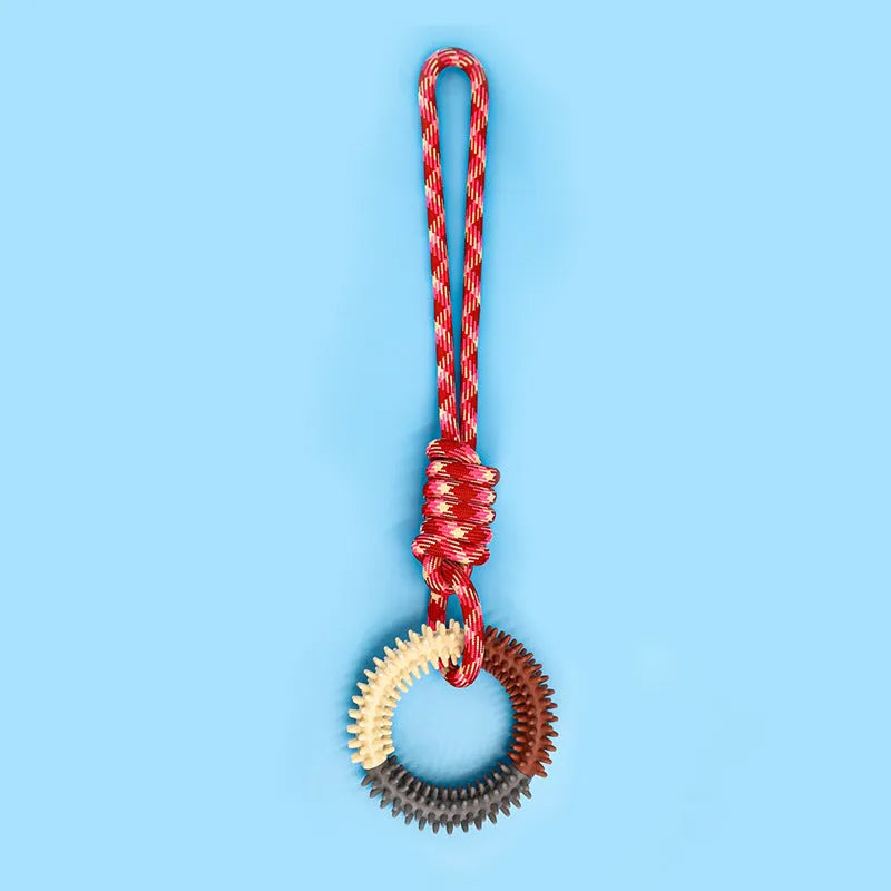 Blue, red, and rose red braided rope dog toy with a large central knot.