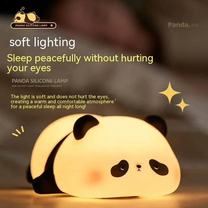 Cartoon panda head shaped silicone night light for children on a bedside table.