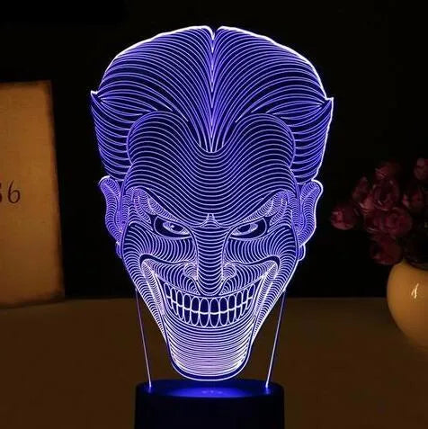 Compact USB-powered 3D LED desk lamp with a touch switch and remote control on a desk.