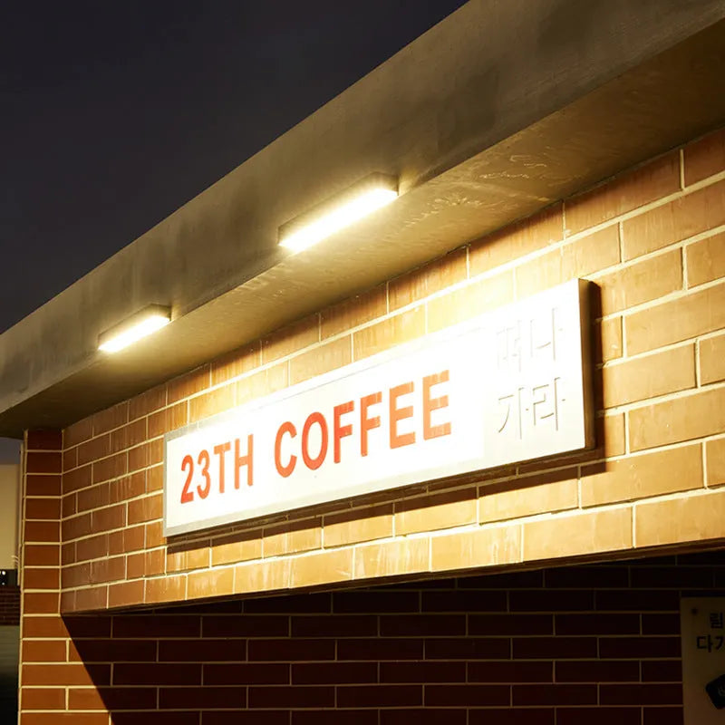 Black solar-powered outdoor wall lamp with IP65 rating for garden installation