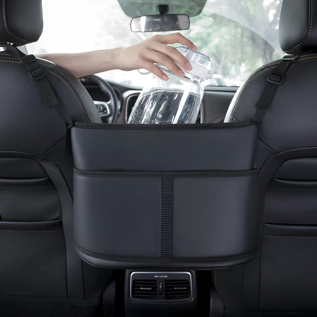 Black leather car seat storage bag with a carbon fibre pattern, shown in a vehicle seat gap.