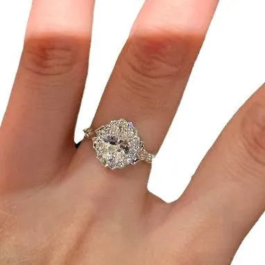 Close-up of a silver women's ring with an adjustable geometric band and a large oval bridal bouquet style diamond cluster.