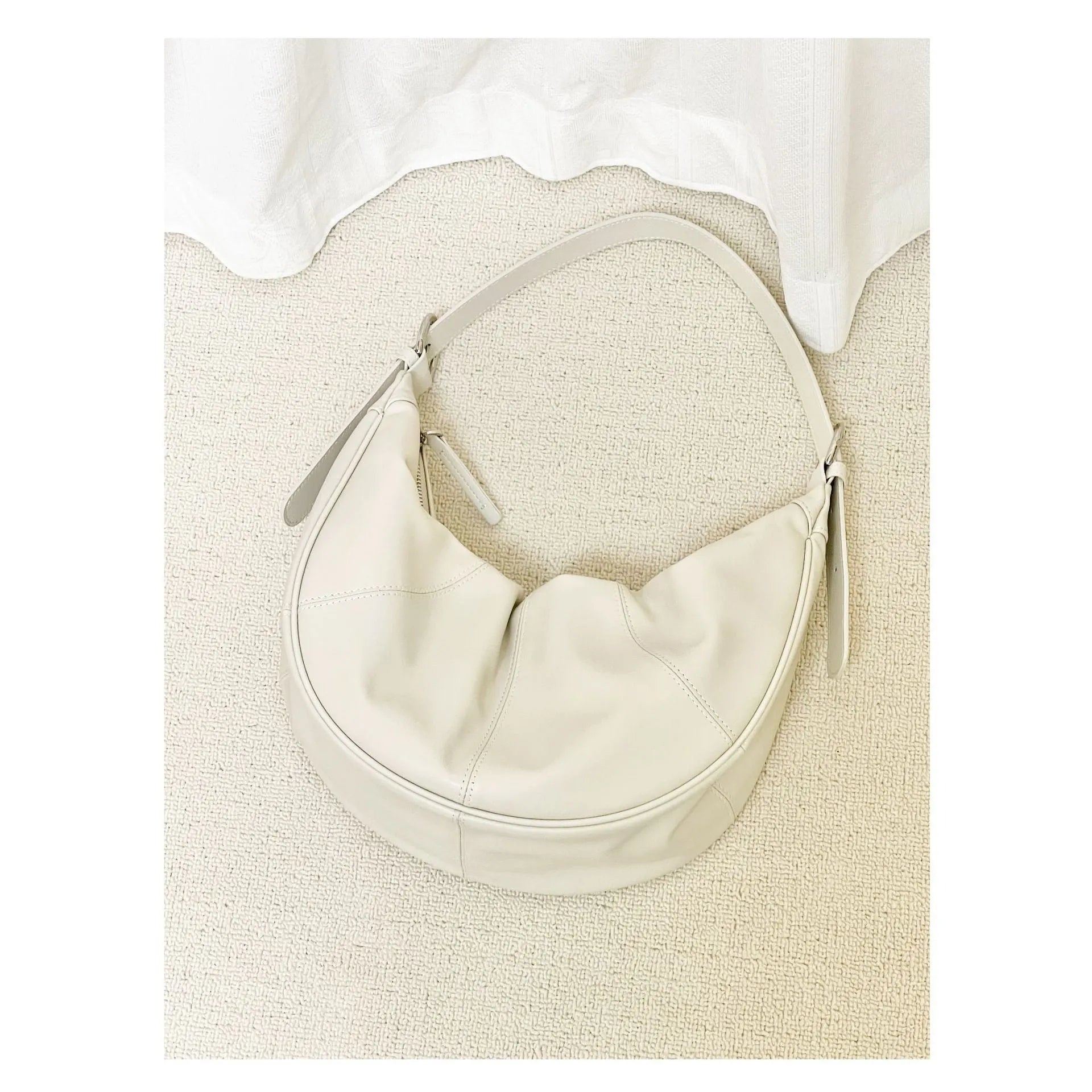 Women's soft cowhide leather dumpling-shaped shoulder bag in silver colour with double straps.
