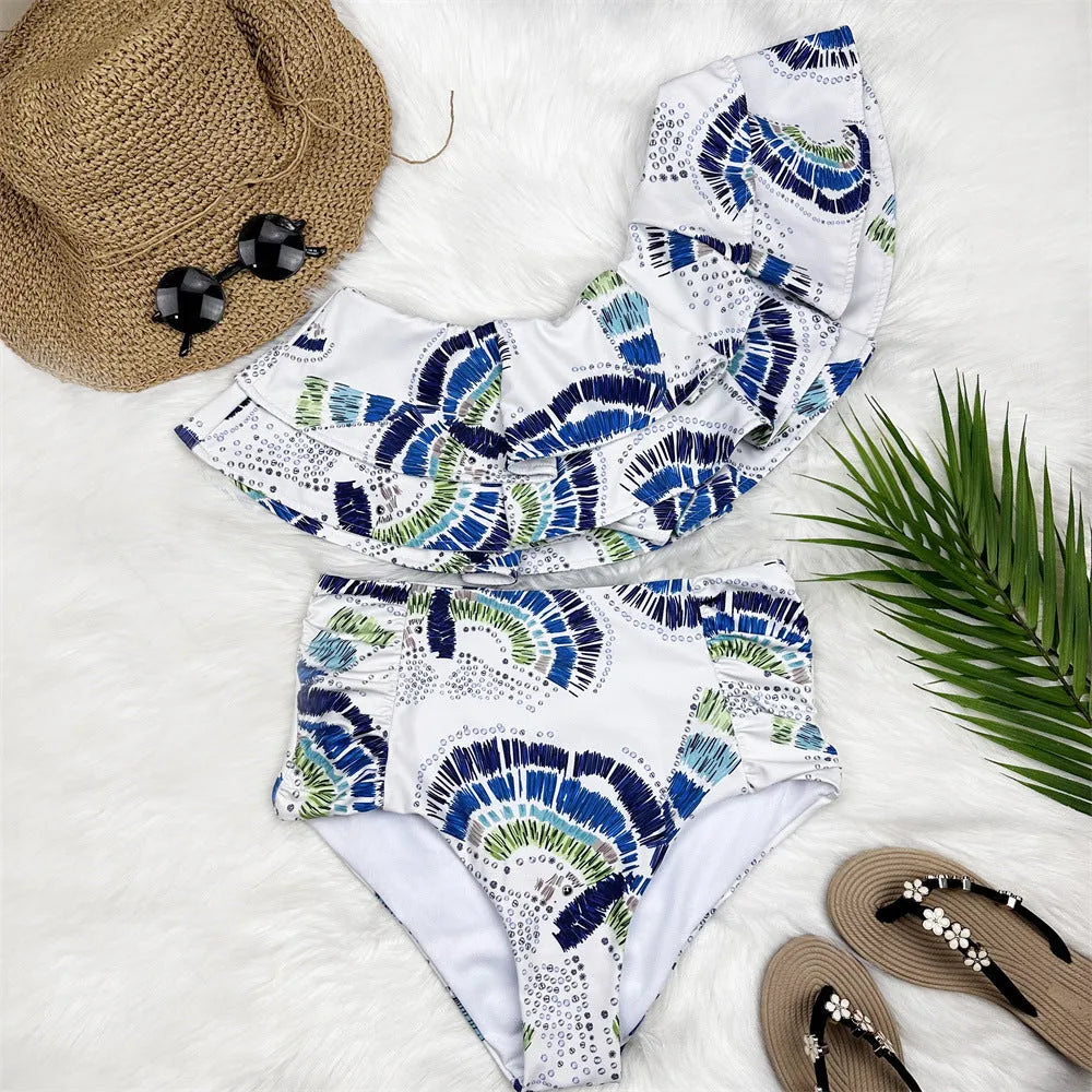 White women's one-shoulder bikini with large lotus leaf detail and split-leg design.