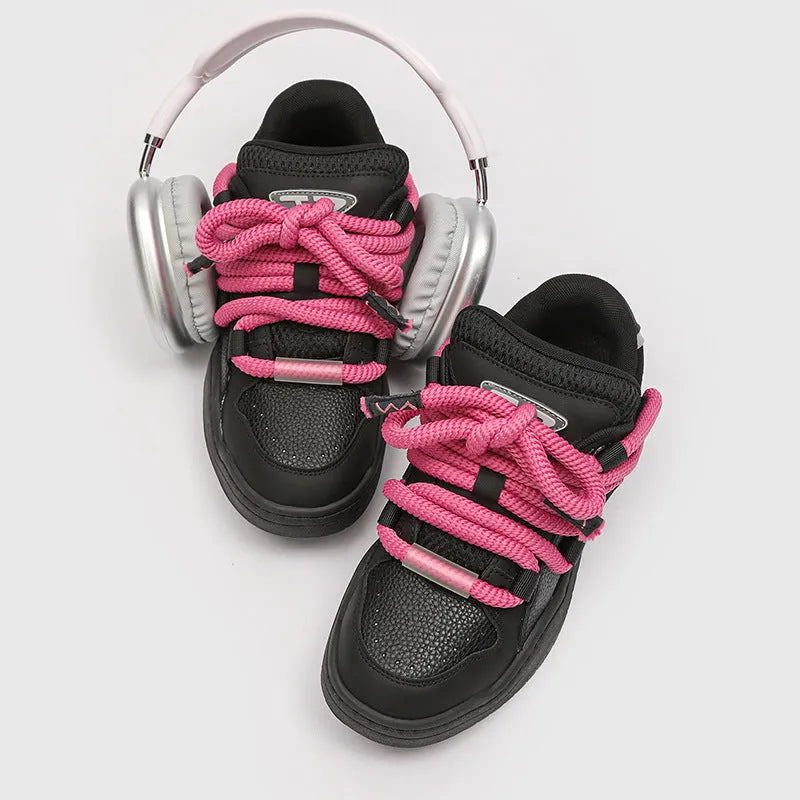 Pair of low-top unisex casual sneakers with thick flat rubber sole and lace-up front in a solid colour.