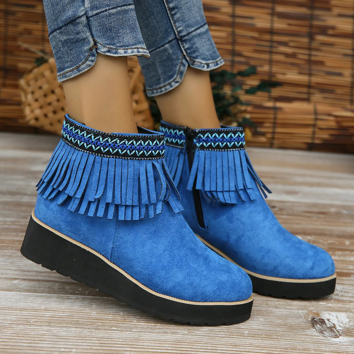 Women's suede ankle boots with a wedge heel, side zipper, and tassel detail in dark brown.