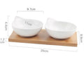 Ceramic multi-compartment dried fruit dish plate on a wooden board, showing separate sections for snacks.