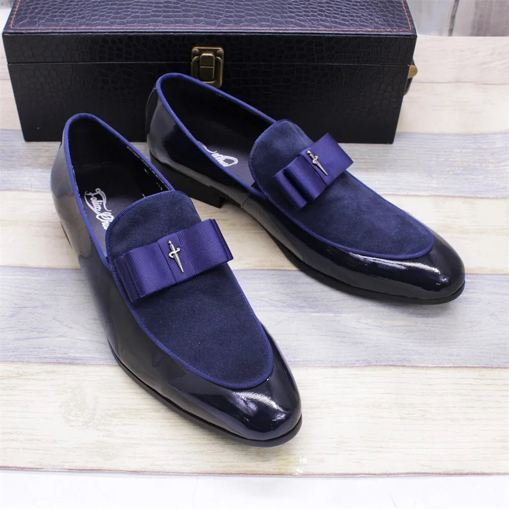 Men's black tassel loafer shoe with matte leather and glossy patent leather detail on a white background.