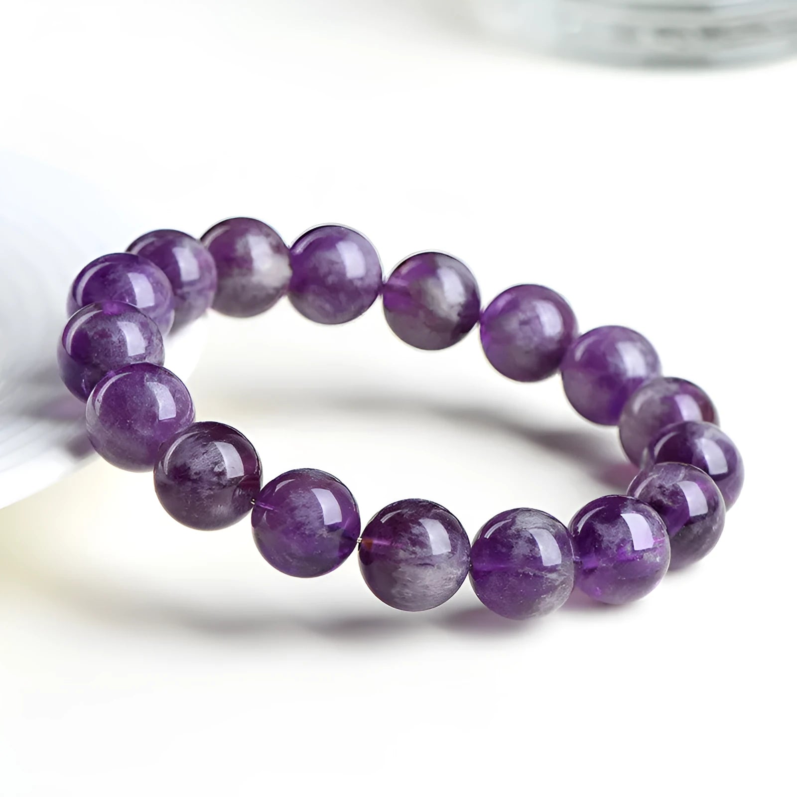 Snow mountain purple feather amethyst crystal bracelet with scattered beads and Ruyi pattern on a wrist.
