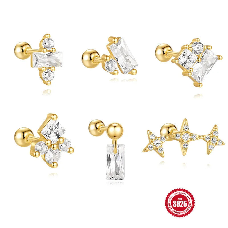 Close-up of women's flower-shaped sterling silver stud earrings with red square gravel stones and a gold electroplated finish.