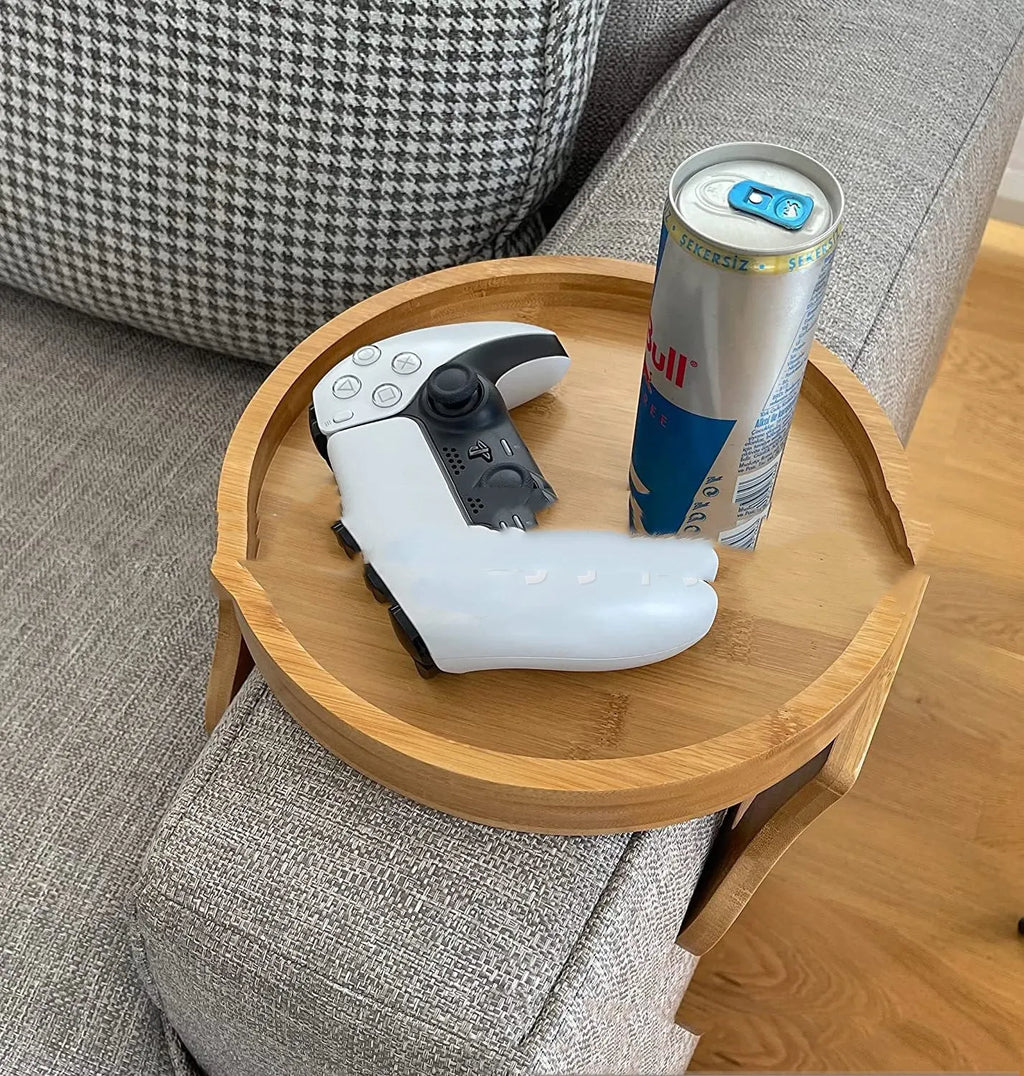 Wooden clip-on sofa tray table with carved surface in bamboo colour, attached to armrest holding snacks and remote
