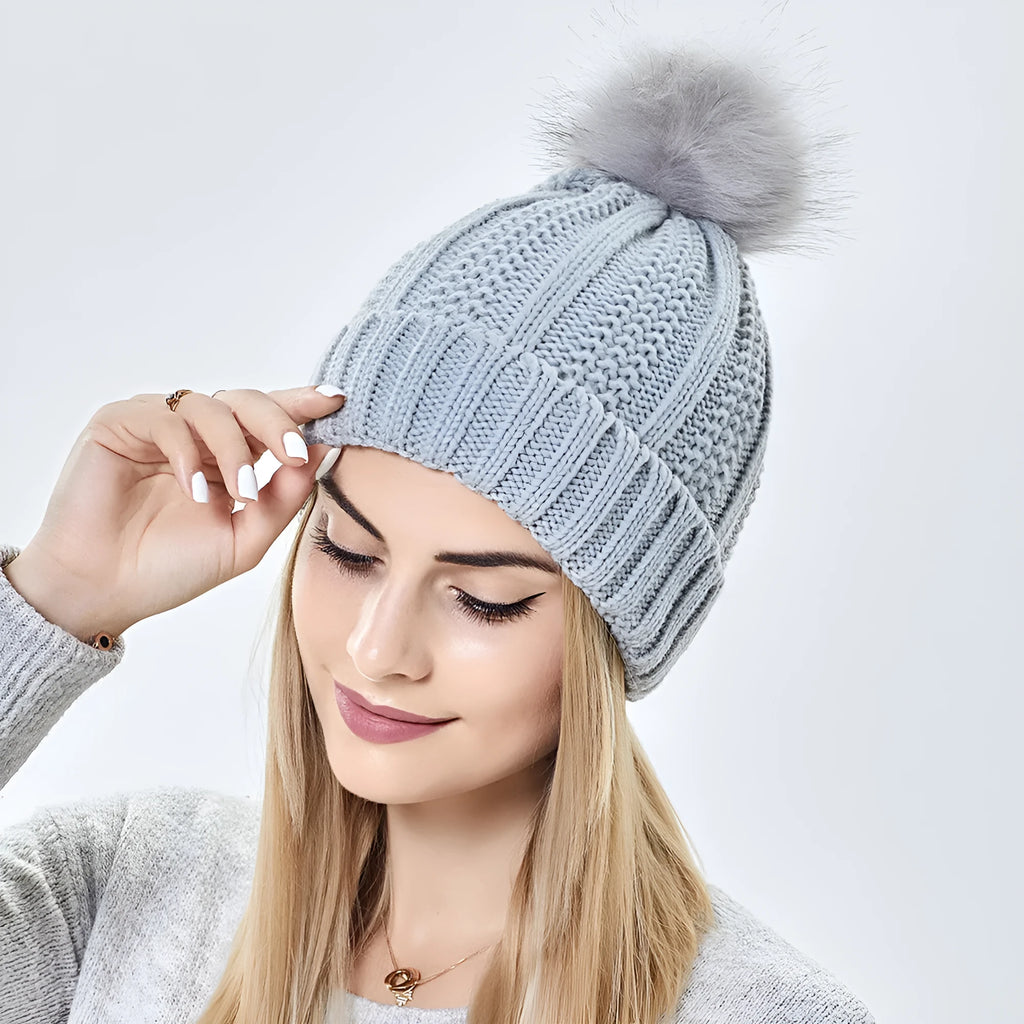 Women's knit beanie hat with faux fur pom pom in wine red, showing satin lining with paisley pattern.