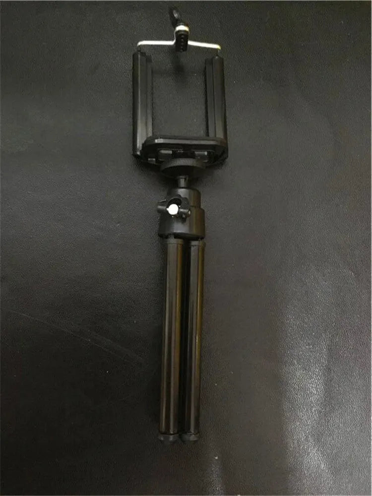 Black aluminium desktop phone holder with a two-section bracket on a wooden desk.
