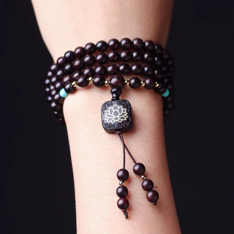 Zambia rosewood Buddha beads bracelet with 0.6 cm beads and flat lotus pendant on wooden surface